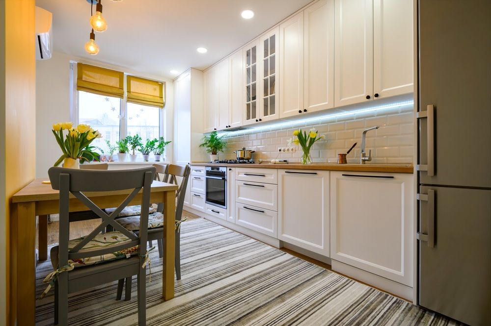 A Kitchen With White Cabinets, a Table and Chairs — Gavin Cummings Kitchens in Dubbo, NSW