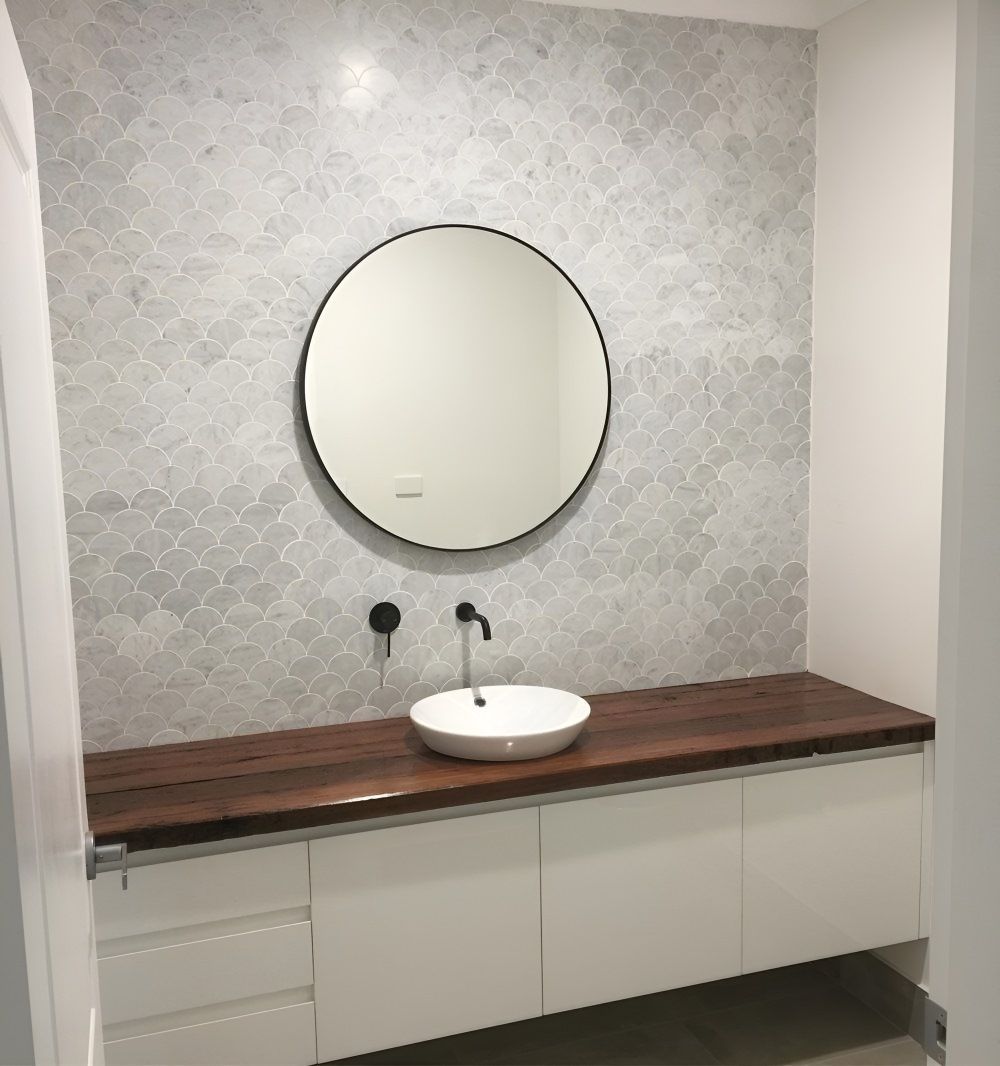 A Bathroom With A Sink And A Round Mirror — Gavin Cummings Kitchens in Dubbo, NSW