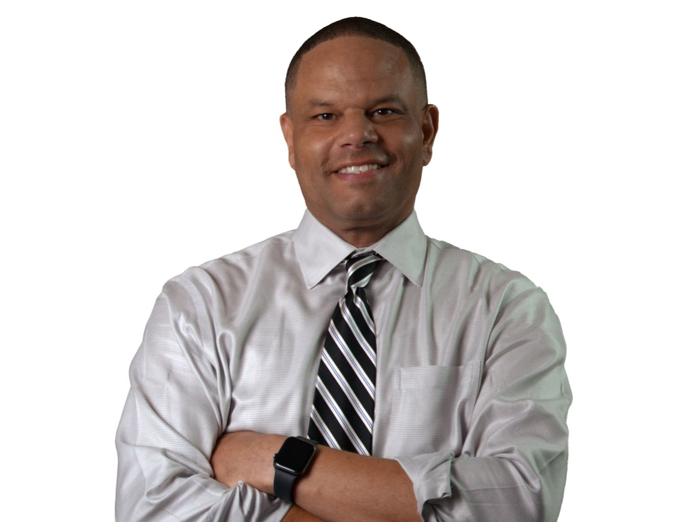Man in light button-down shirt and striped tie, arms crossed, smiling.