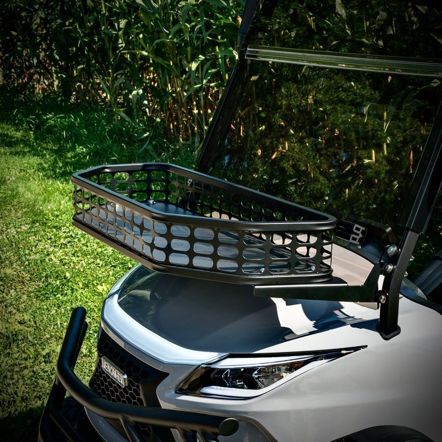 White golf cart with a front basket parked on grass near trees