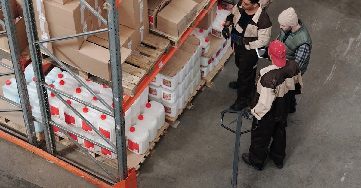 Een groep mensen staat rond een palletwagen in een magazijn.