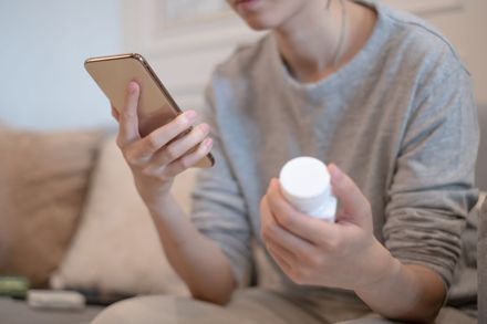 Safewell Personal Safety and Wellness App Prescription access. woman holding a bottle of pills and cell phone.