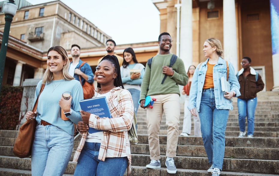 A group of students are walking down the stairs of a building.