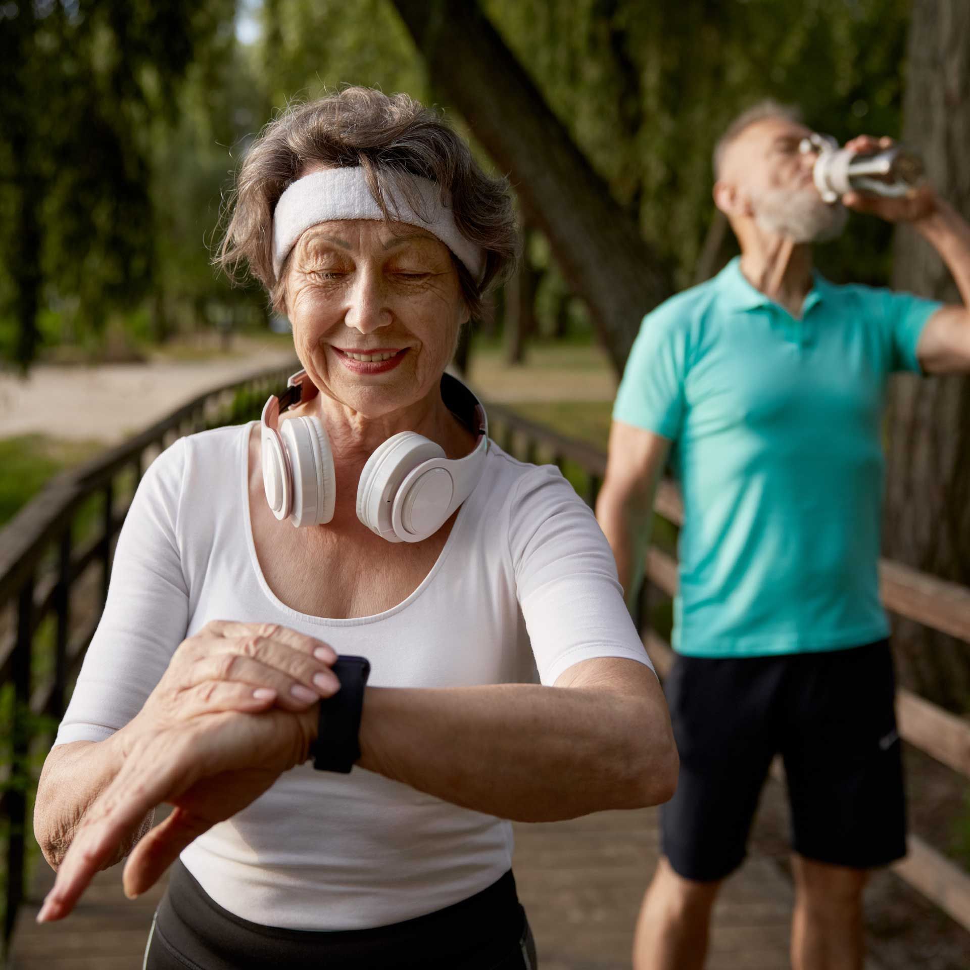 Senior Woman Checking Wearable Device while outdoors workout
