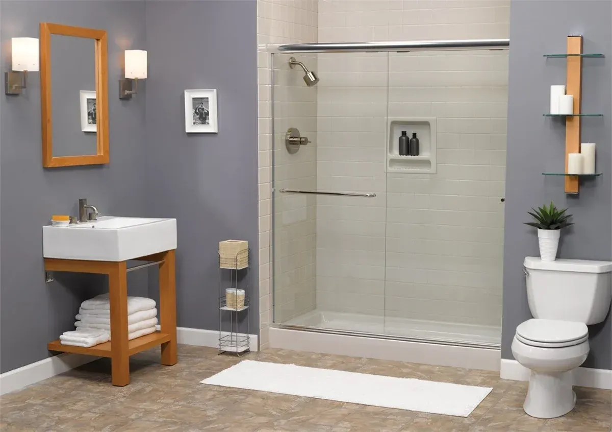 Modern bathroom with gray walls, glass shower, white vanity, toilet, and wall shelves