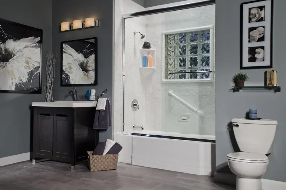 Accessible bathroom with walk-in shower, vanity, and toilet in gray and white tones