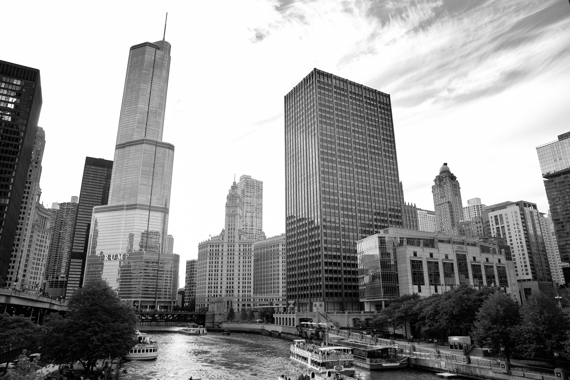 Black-and-white city skyline with tall office buildings and a river in the foreground