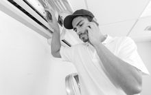 Technician inspecting an air conditioner unit while holding a phone