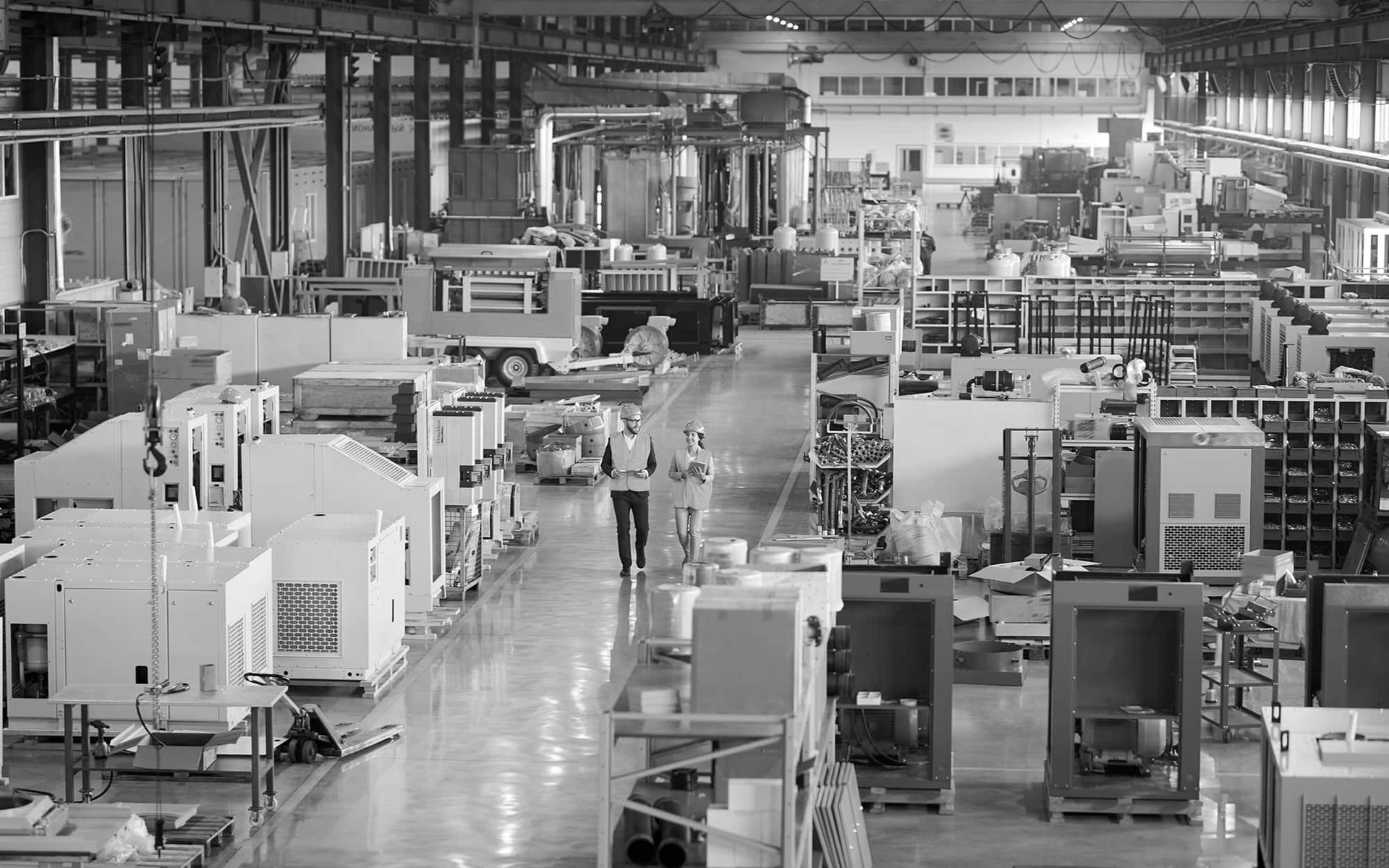 Factory floor with rows of industrial machines and equipment in a large manufacturing hall