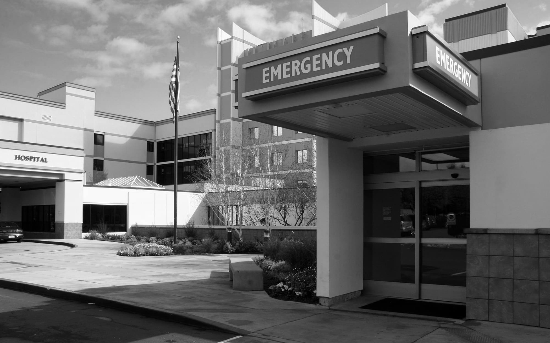 Hospital emergency entrance with a covered drop-off area and brick building exterior.