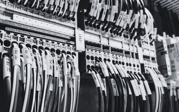 Rows of hanging baseball bats with price tags in a store display, in black and white.