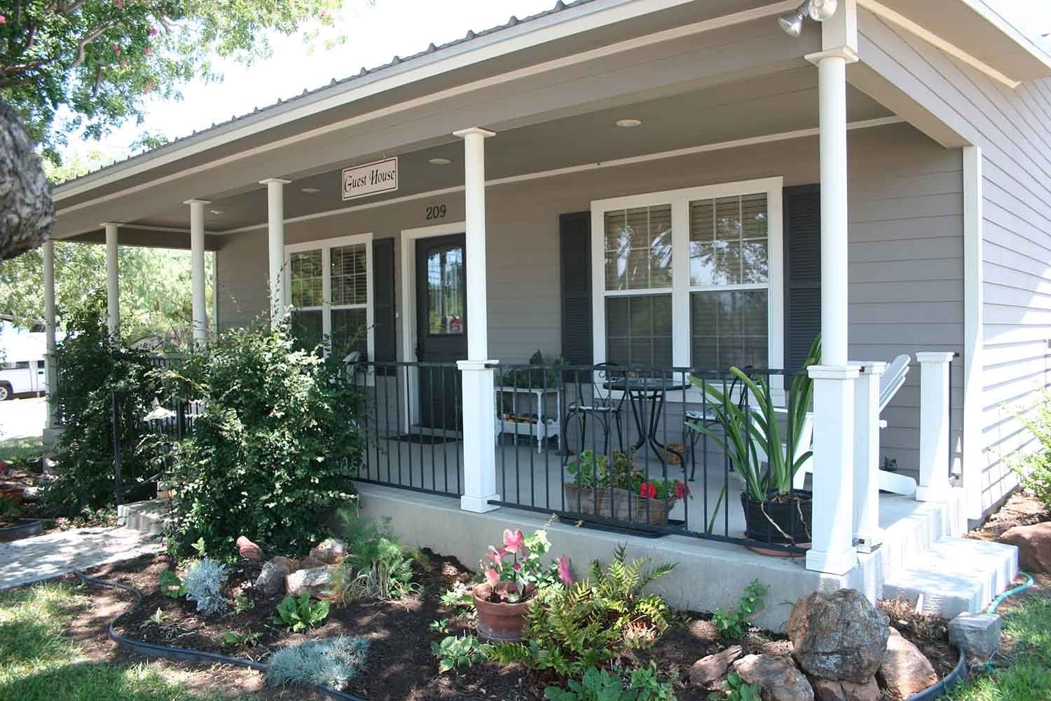 A small house with a porch and a sign that says ' 1822 ' on it