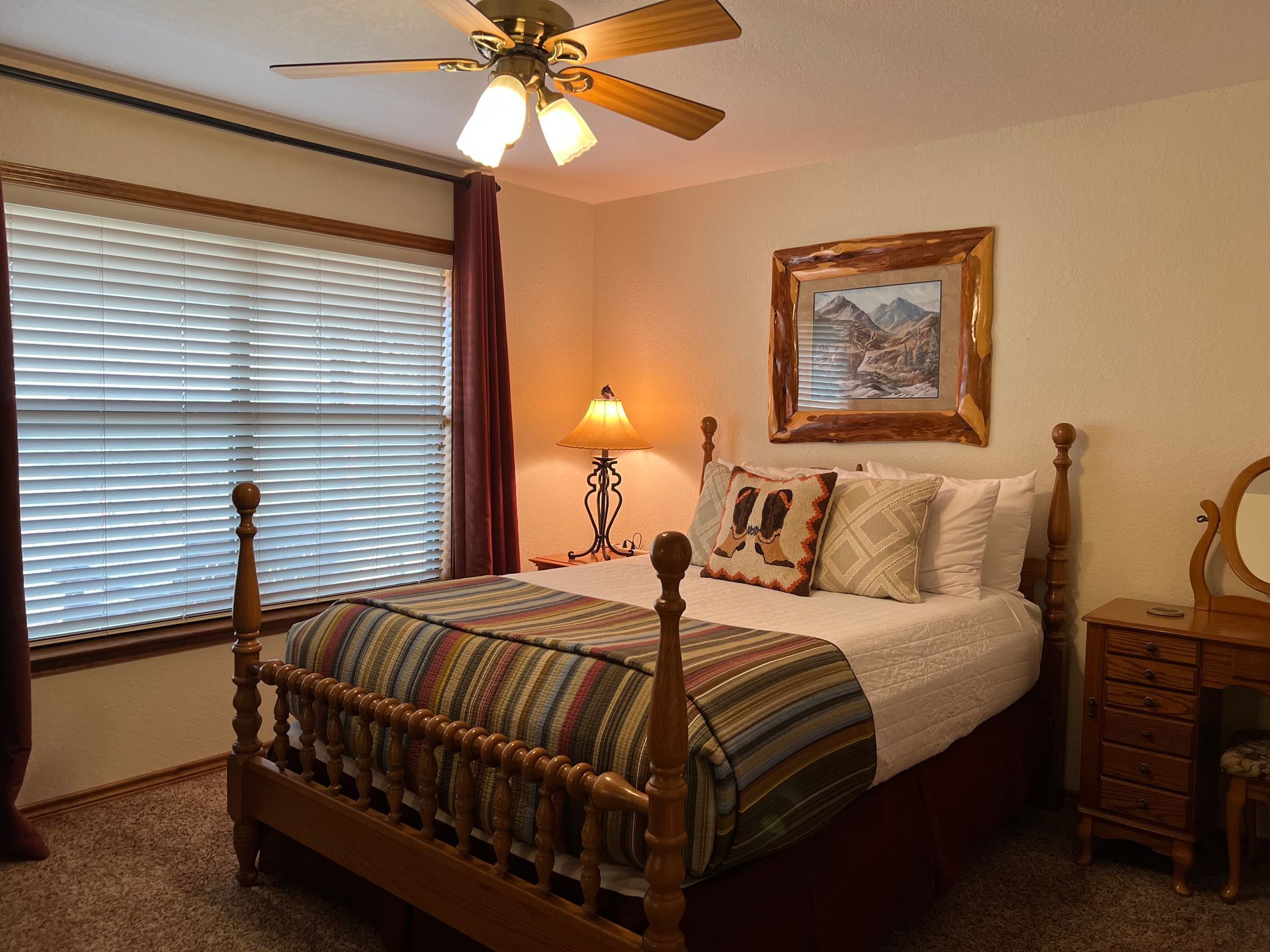 A bedroom with a king size bed and a ceiling fan