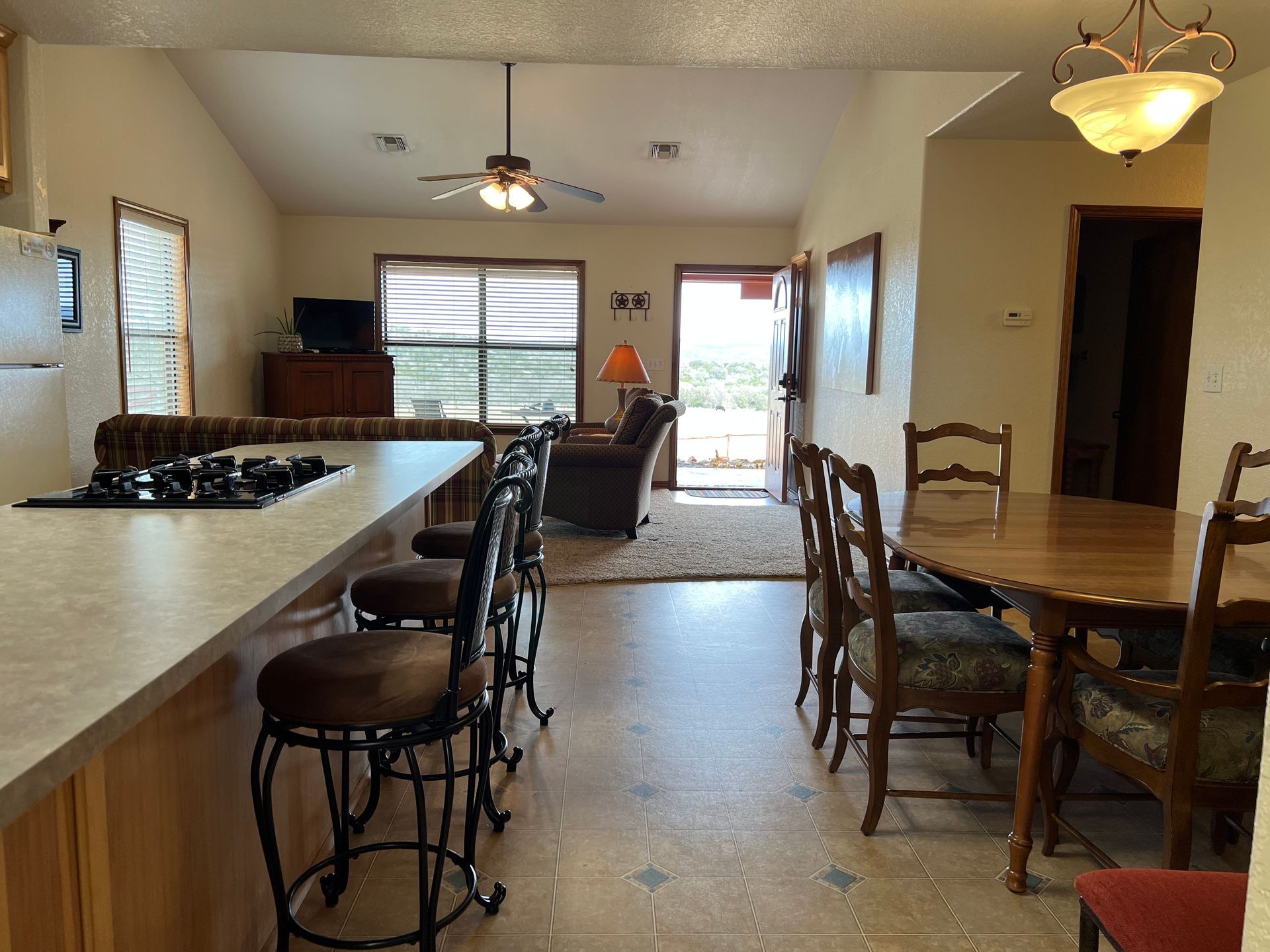 A kitchen with a table and chairs and a stove top oven