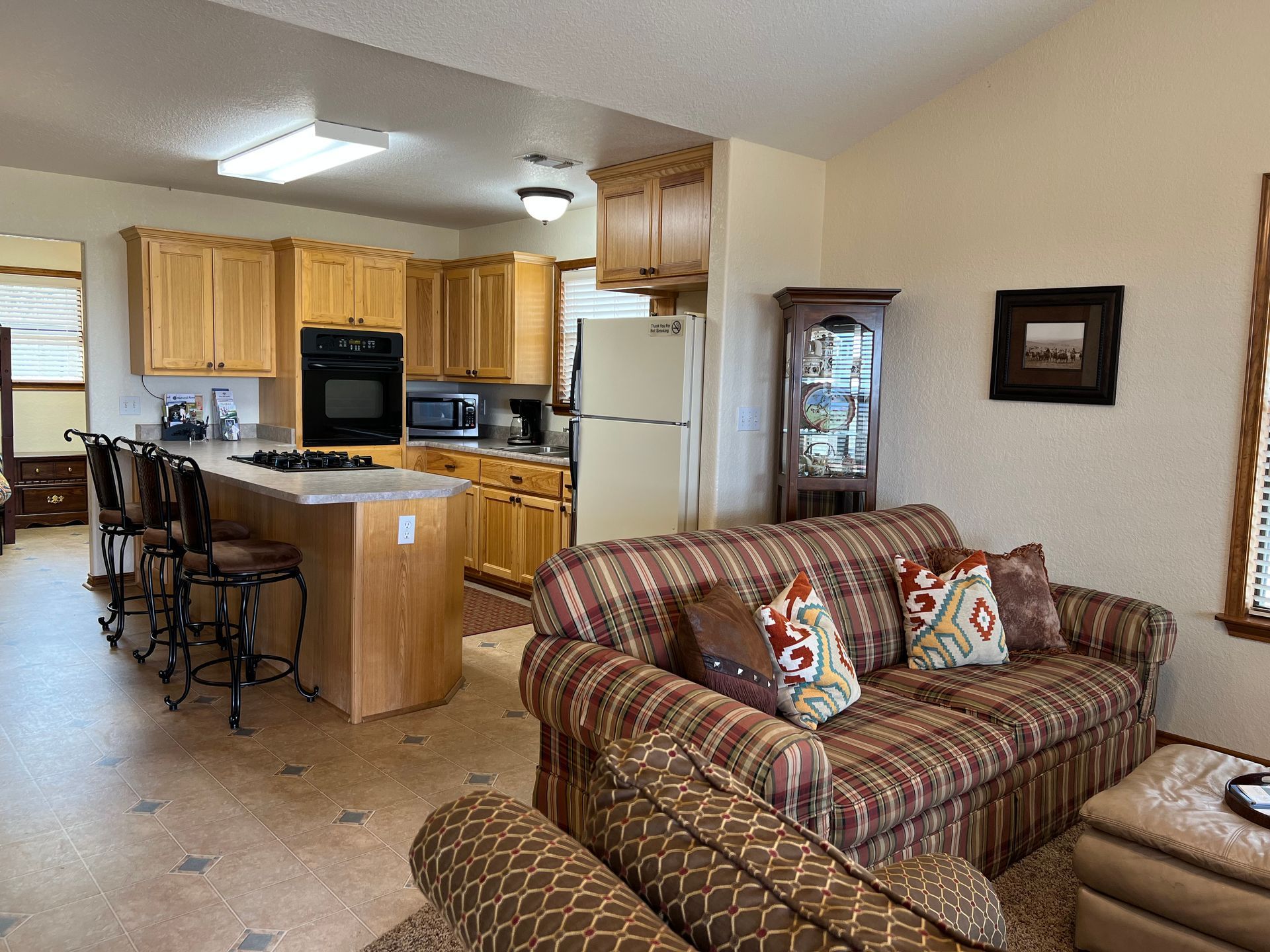 A living room with a couch and a kitchen in the background