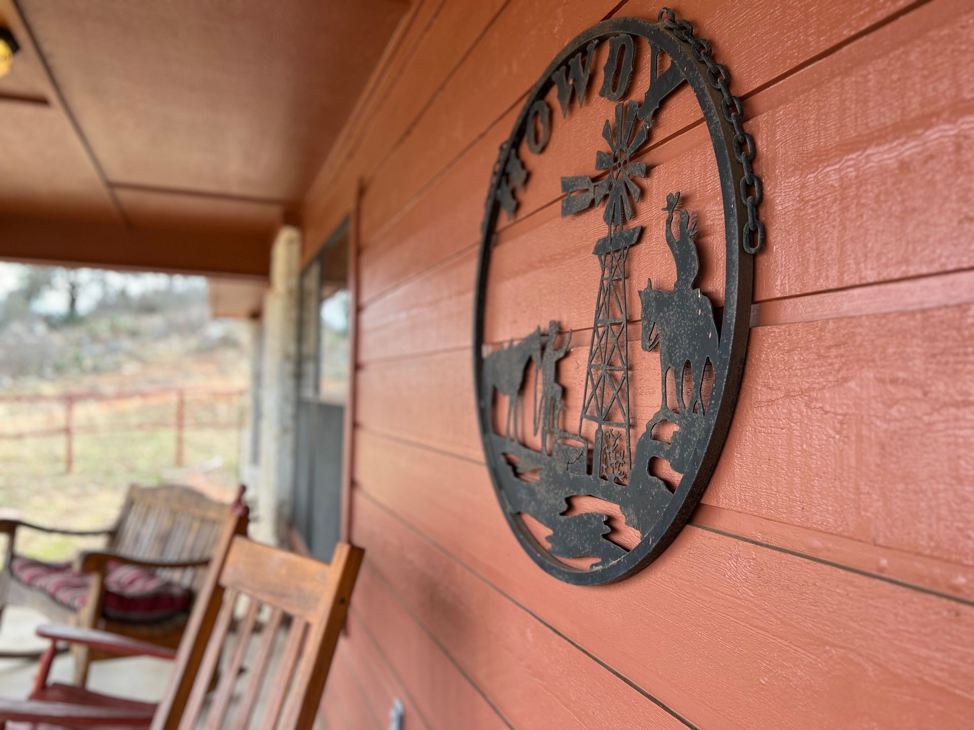 A porch with rocking chairs and a sign on the wall