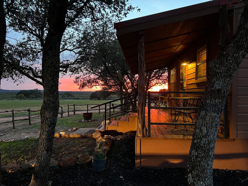 A house with a porch and a sunset in the background