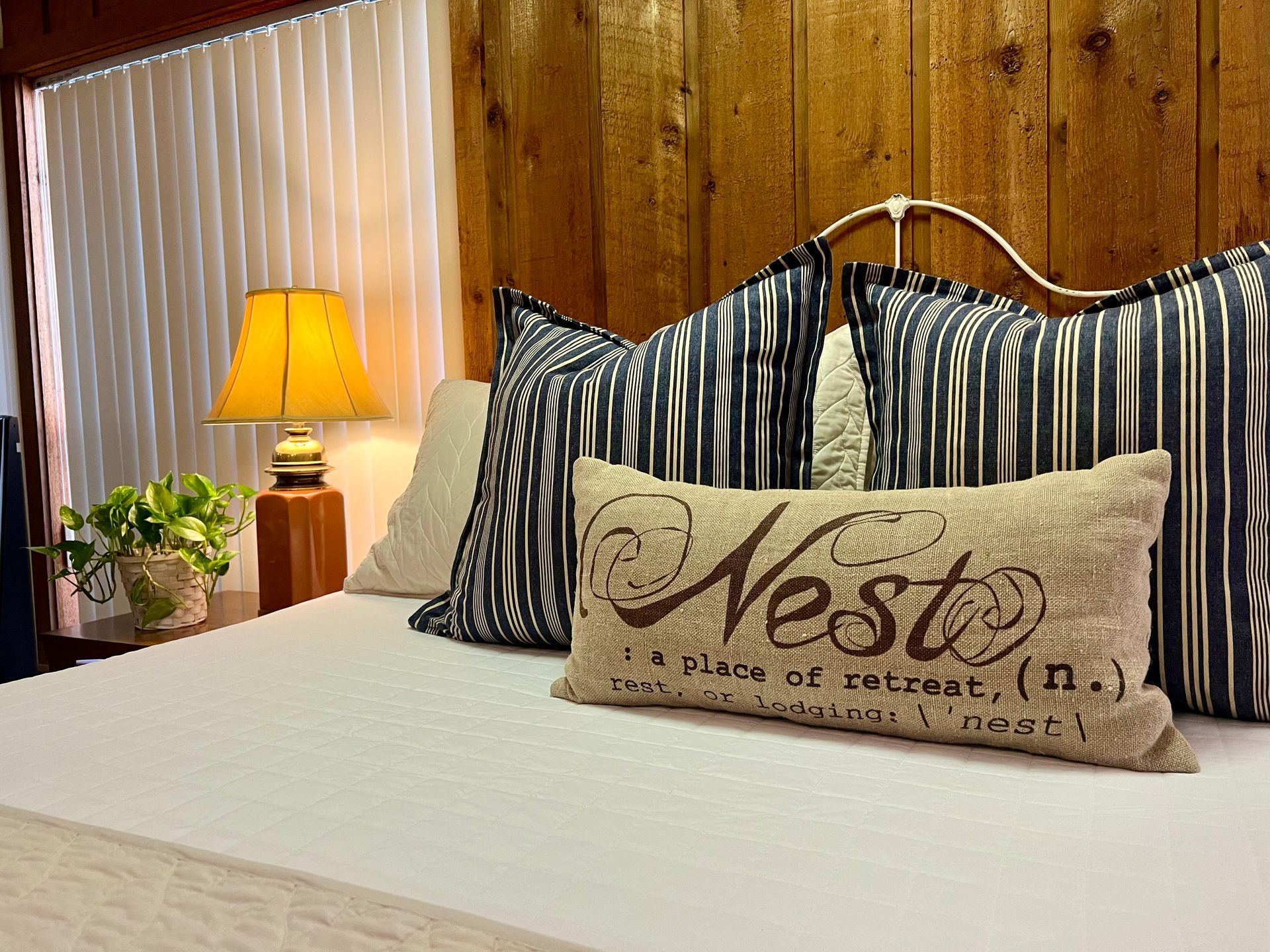 A bed with a pillow that says nest on it.