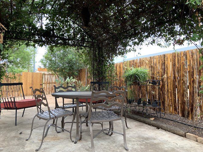 A patio with a table and chairs under a pergola.