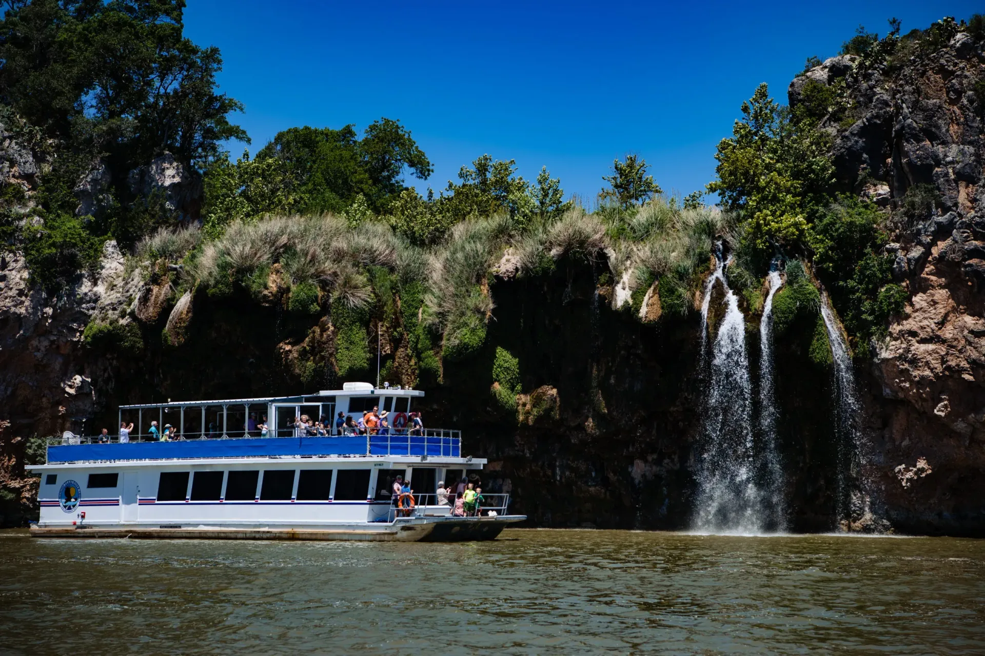 A boat is in the water near a waterfall