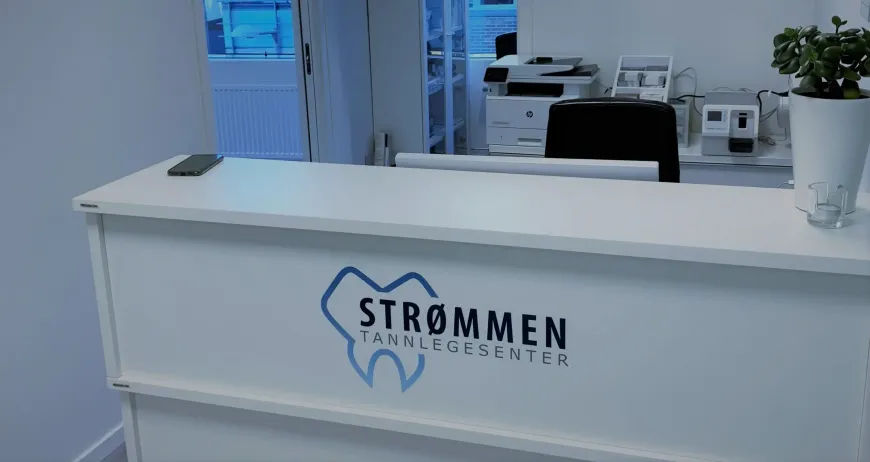Seks kvinner i skrubber smiler i lyse omgivelser innendørs.