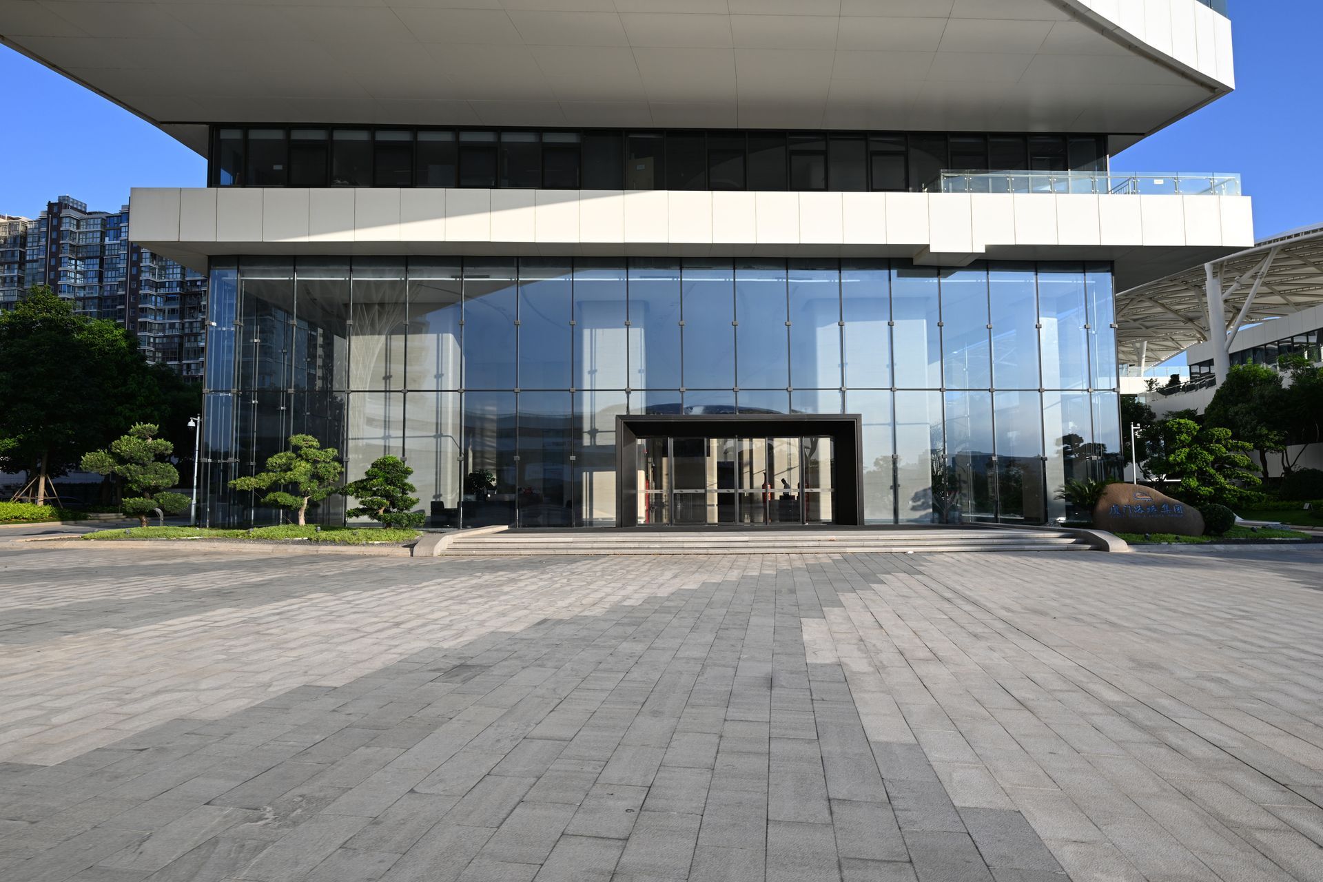 A large building with a lot of windows and a brick walkway in front of it.