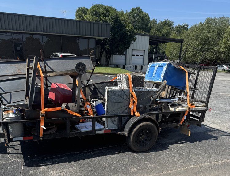 Utility trailer loaded with tools and equipment parked on a sunny street