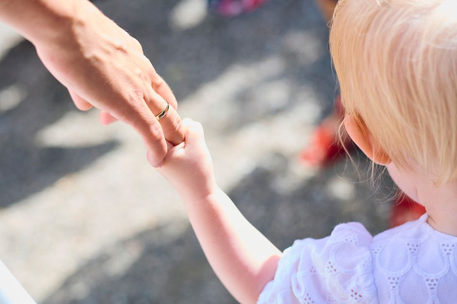 Parent holding a child's hand at a medical appointment