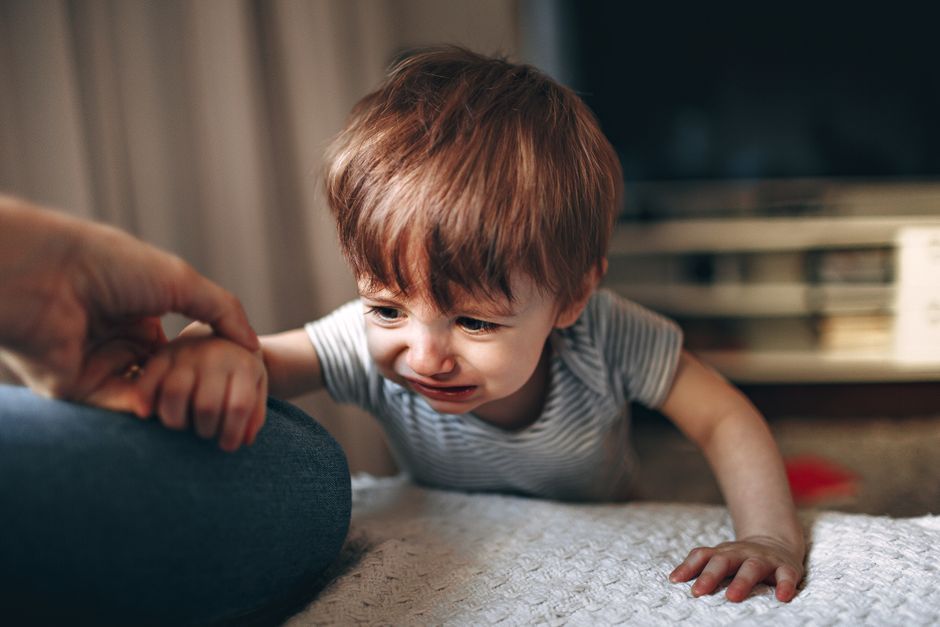 A parent comforting an upset young child after a fall