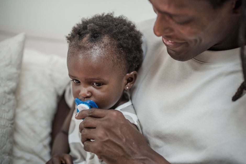 A toddler with a pacifier in their mouth
