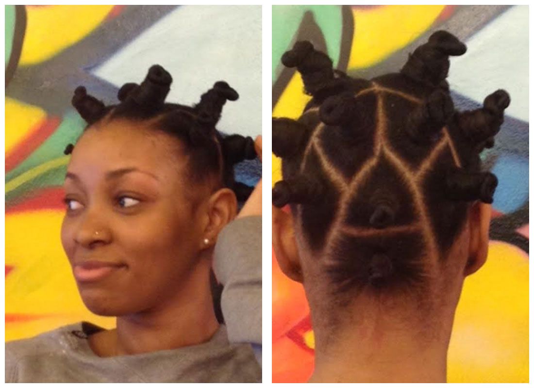 A woman with a giraffe hairstyle is smiling in front of a colorful wall