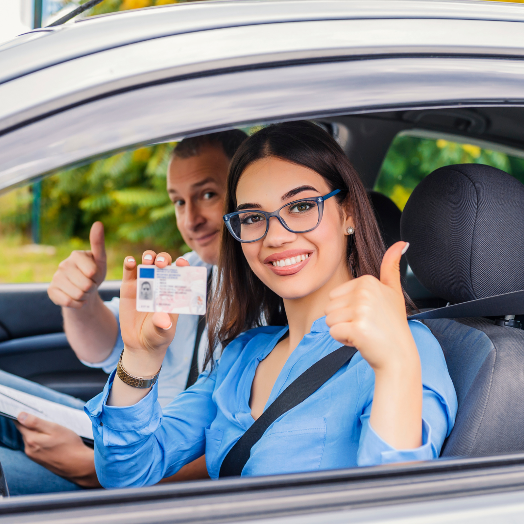 Um homem e uma mulher estão fazendo sinal de positivo em um carro.
