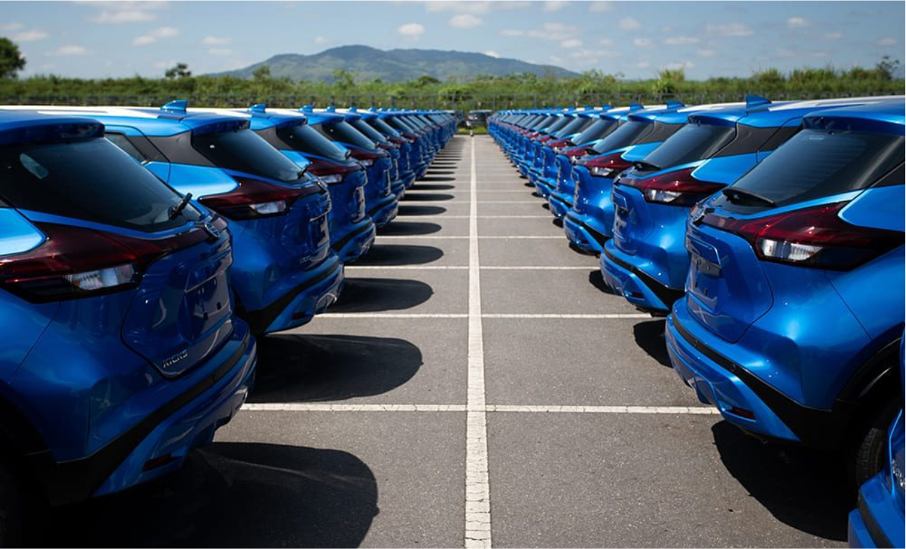 Uma fileira de carros azuis está estacionada em um estacionamento.