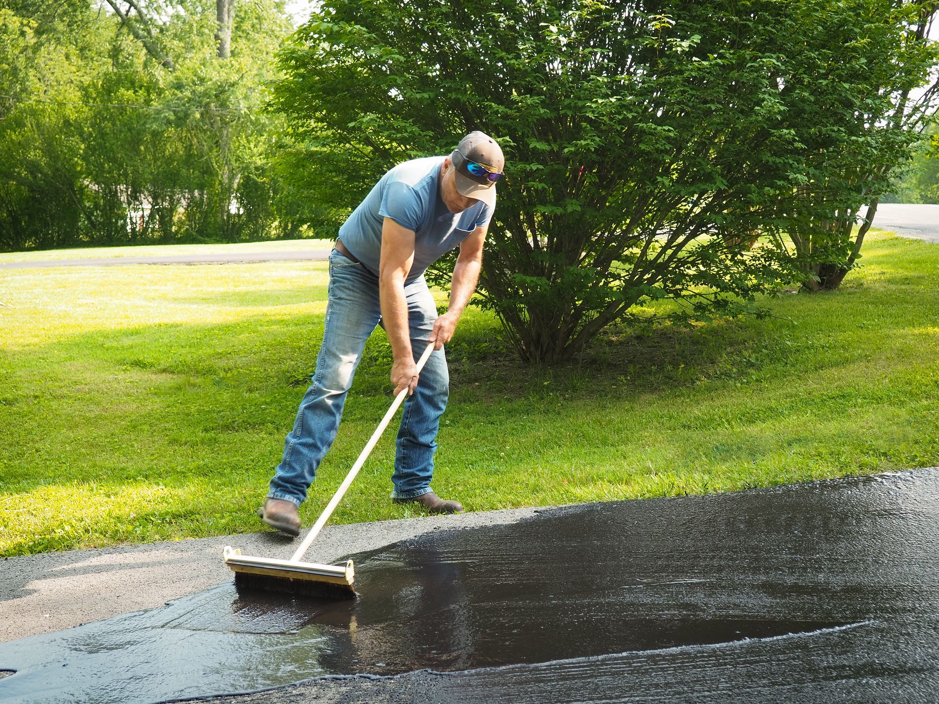 A man sealcoating a driveway.