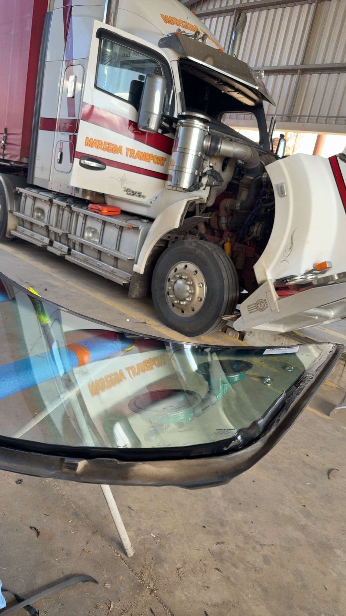 Damaged truck at a crash scene with a detached windshield in the foreground — Far North Windscreens in Mareeba, QLD