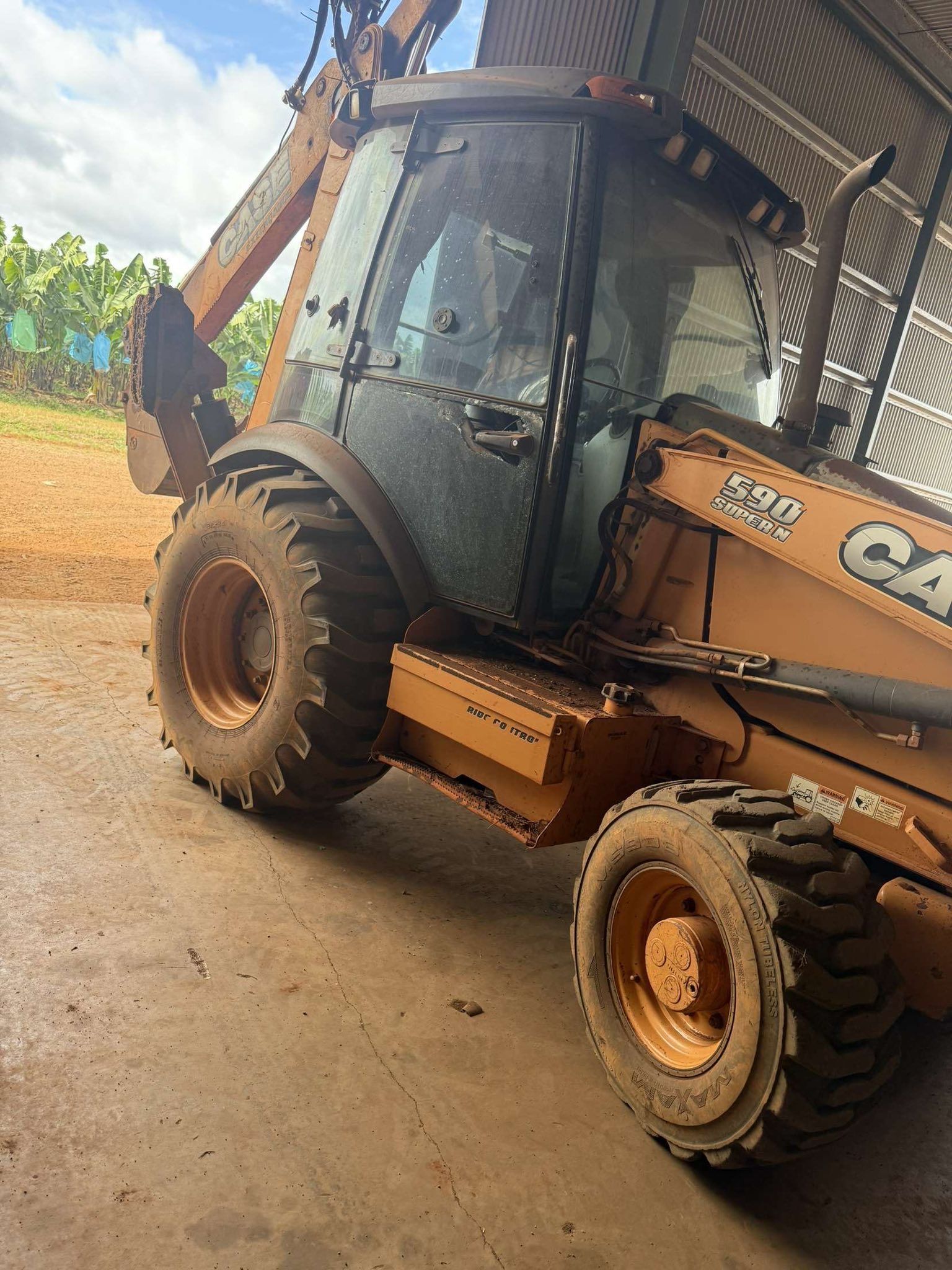 A Tan Case 580 Backhoe Loader Parked — Far North Windscreens in Mareeba, QLD