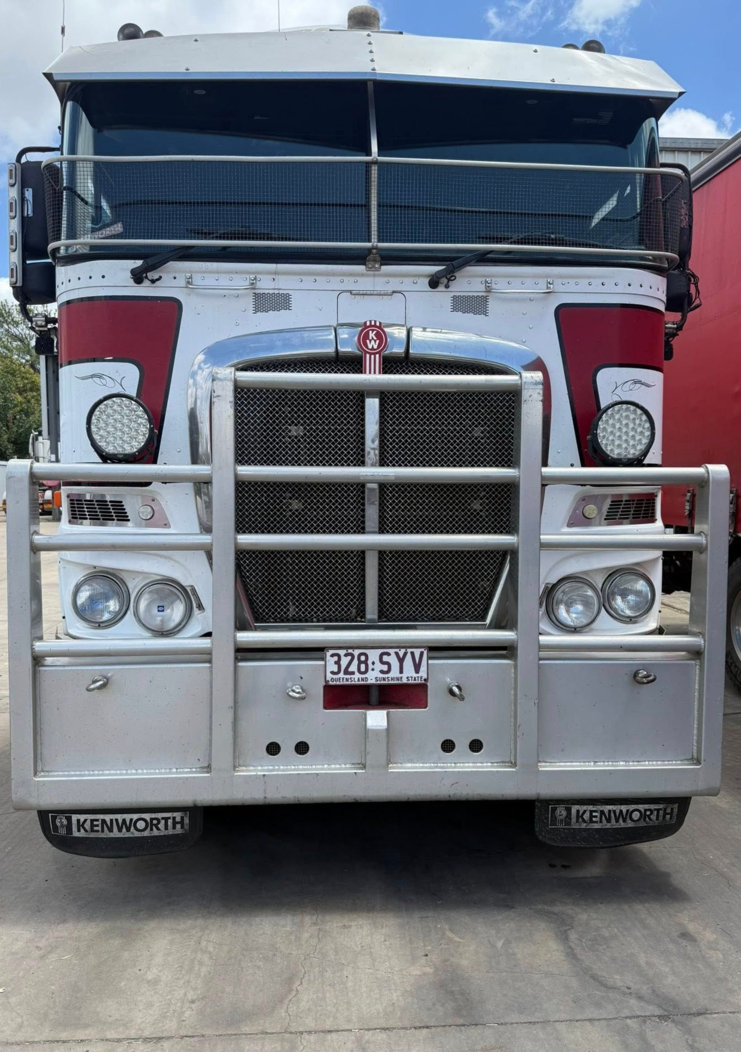 Front view of a large white semi-truck with chrome grille and red accents on a road — Far North Windscreens in Mareeba, QLD