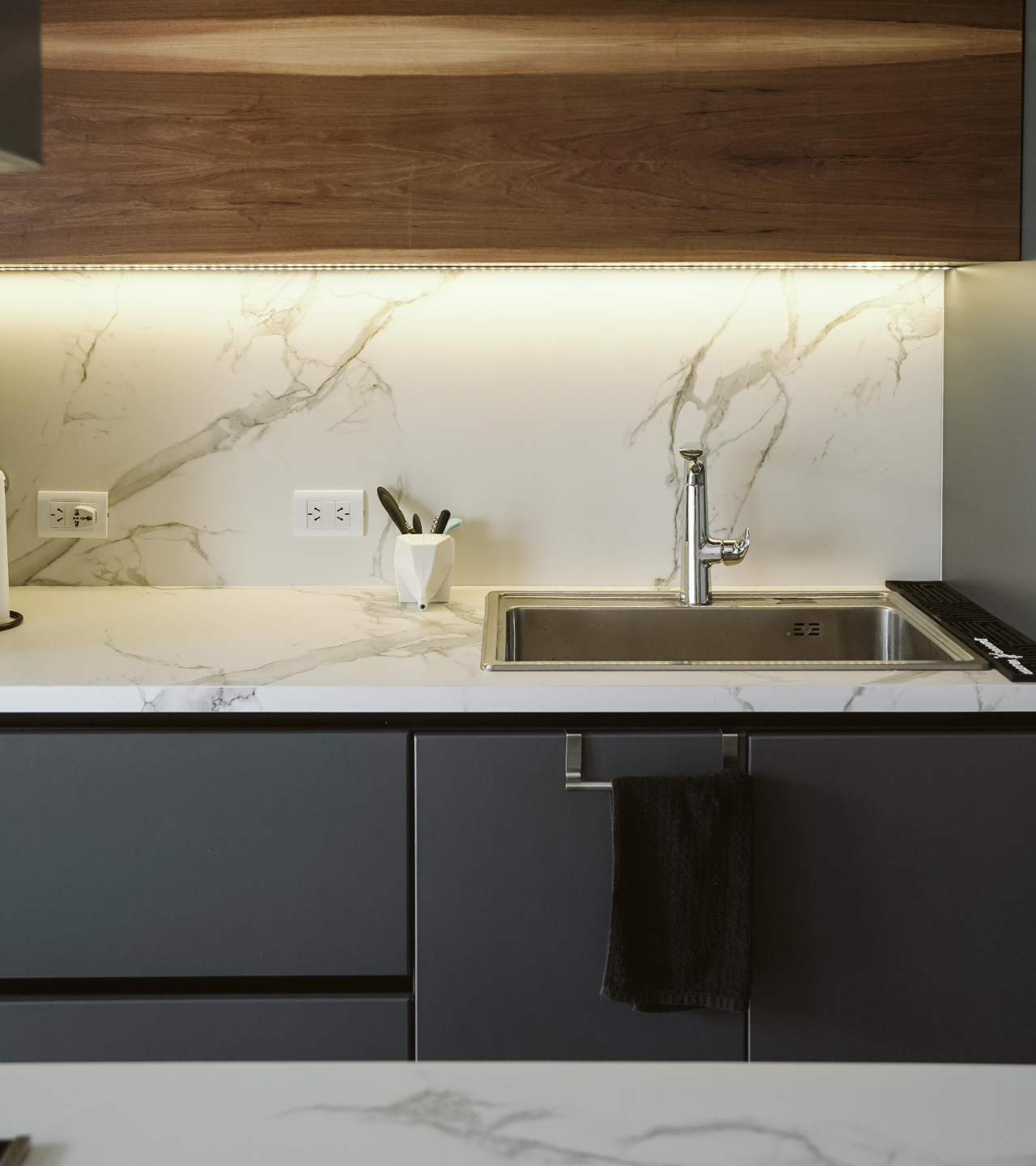 Bathroom with two white bowl sinks on a wood countertop, black faucets, mirrors, and a plant.