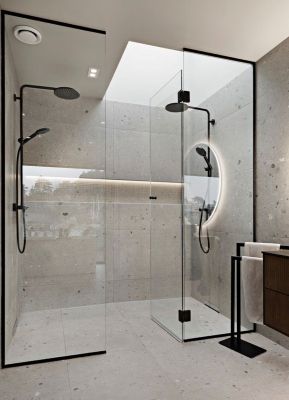 Salle de bain moderne avec cabine de douche en verre, luminaires noirs et murs en pierre gris clair.