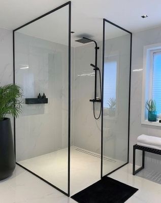 Cabine de douche moderne avec verre à cadre noir, murs blancs et robinet de douche noir.