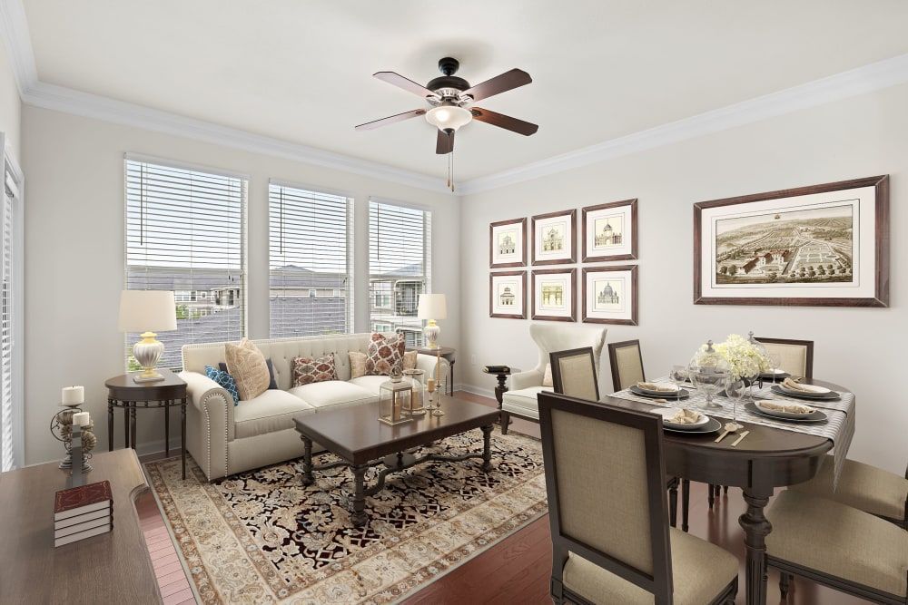 Apartment living room with a couch, table, chairs, and a ceiling fan at Marquis Rockwall in Rockwall, TX.