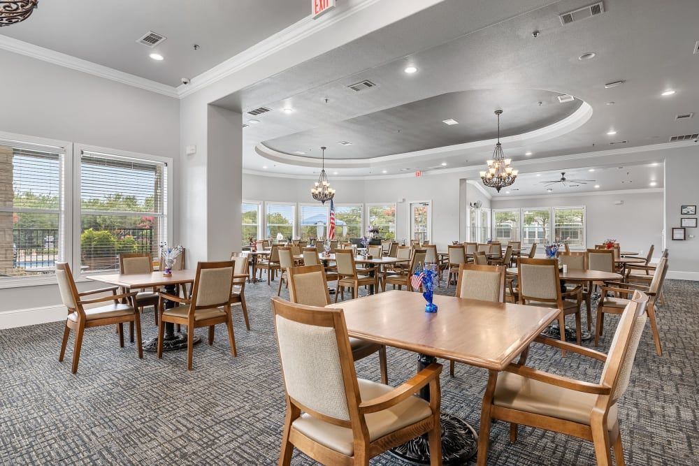 Senior apartment community dining room with tables and chairs at Marquis Rockwall in Rockwall, TX.