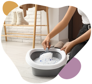 Person hand-washing a white garment in a gray basin on a bright laundry room floor