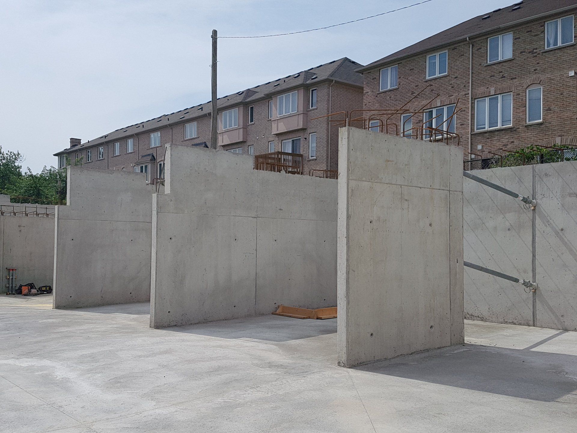 A row of concrete walls in front of a brick building