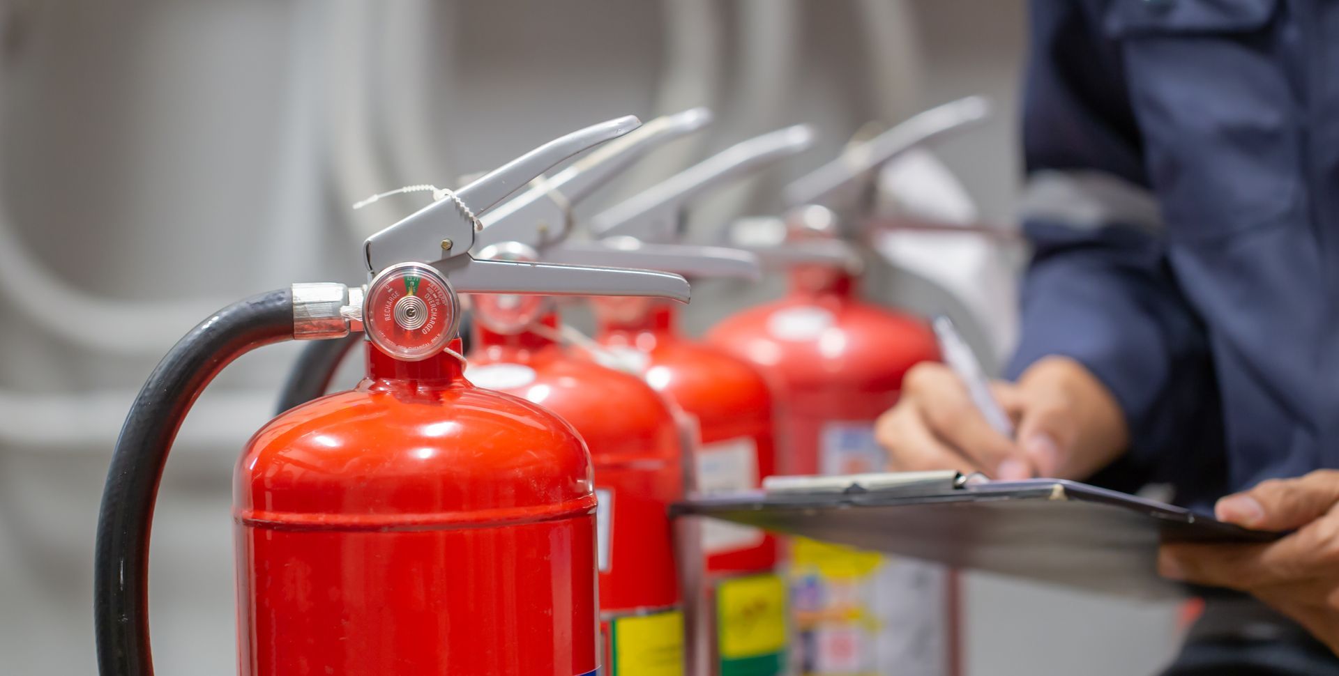 Engineer inspecting fire extinguisher tank, showcasing fire extinguishers for safety compliance.