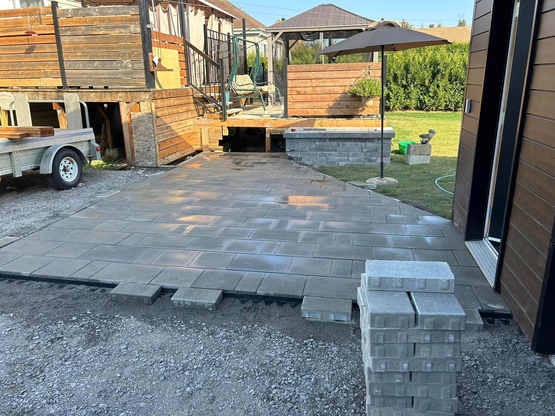 Un patio est en cours de construction dans l'arrière-cour d'une maison.