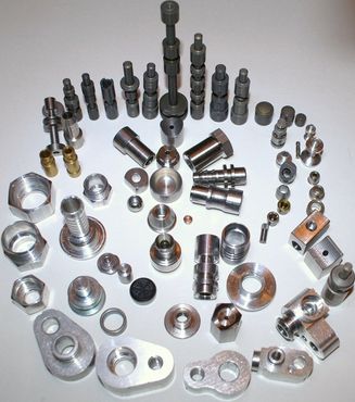 Collection of various metal machine parts, ranging in size and shape, displayed on a white surface.