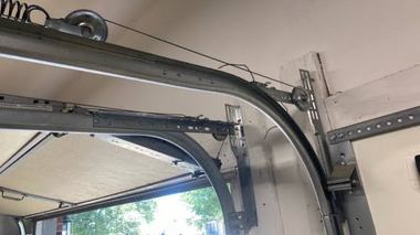 Close-up of a garage door track and opener mechanism mounted along the ceiling.