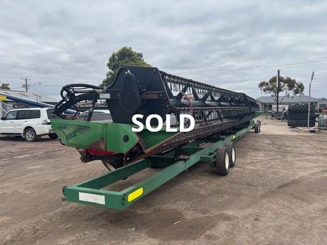 Green trailer-mounted boat with black frame and 