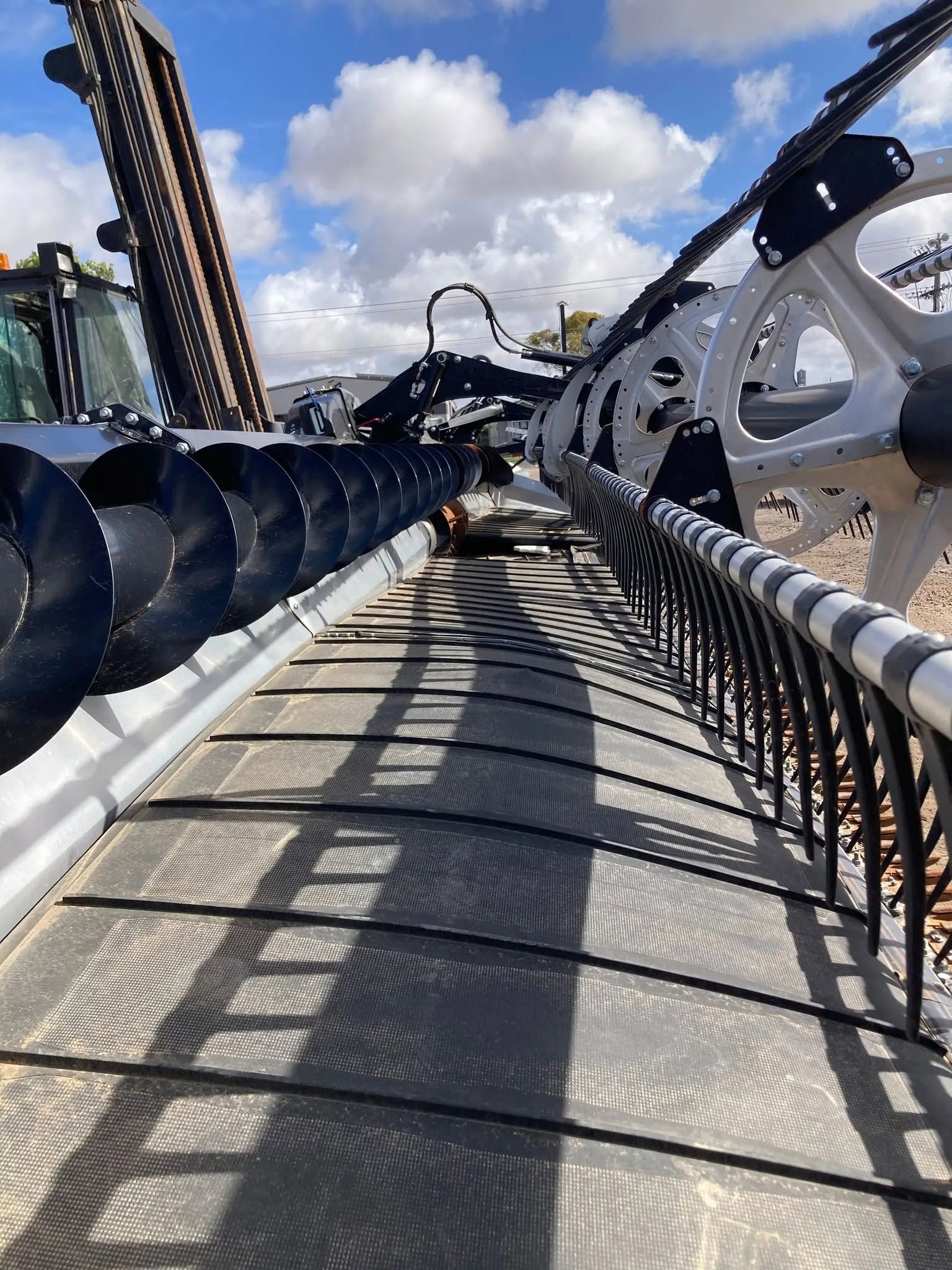 Roller coaster track view from the front car with blue sky and clouds overhead